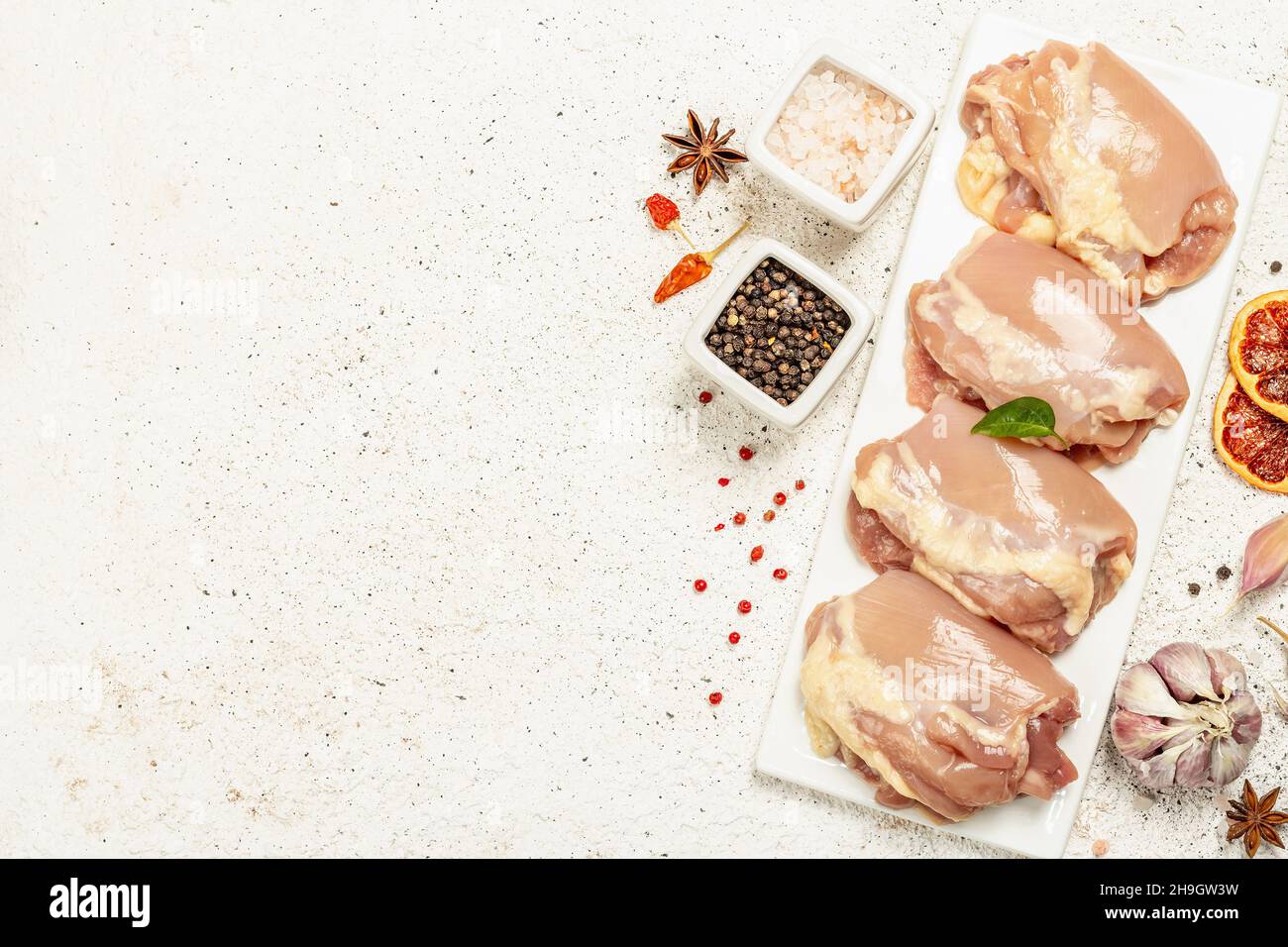 Cuisse de poulet crue sans os ni peau.Un ingrédient utile pour préparer des aliments sains, des épices, de l'ail.Arrière-plan léger, vue de dessus Banque D'Images