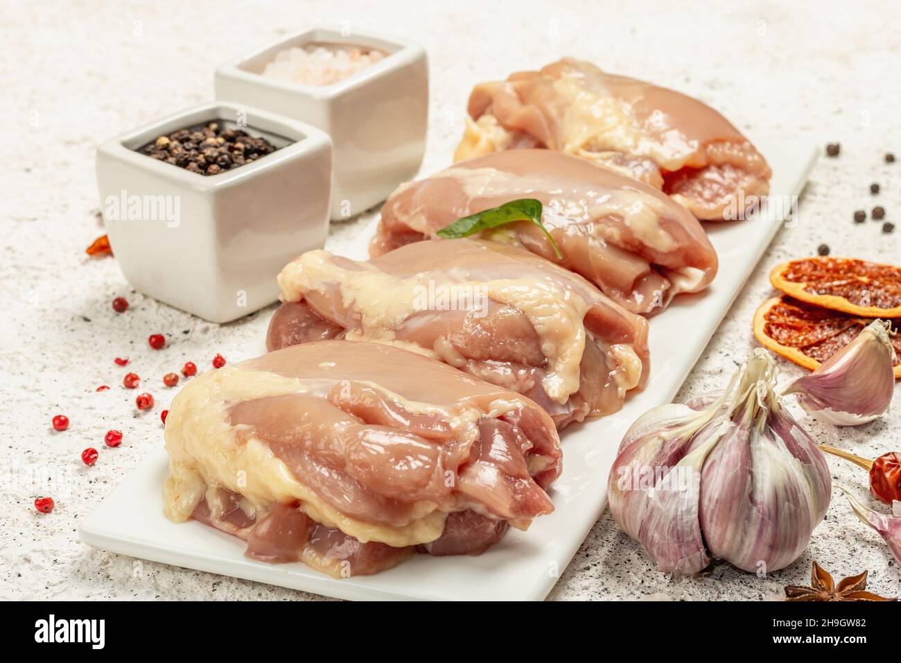 Cuisse de poulet crue sans os ni peau.Un ingrédient utile pour préparer des aliments sains, des épices, de l'ail.Arrière-plan léger, gros plan Banque D'Images