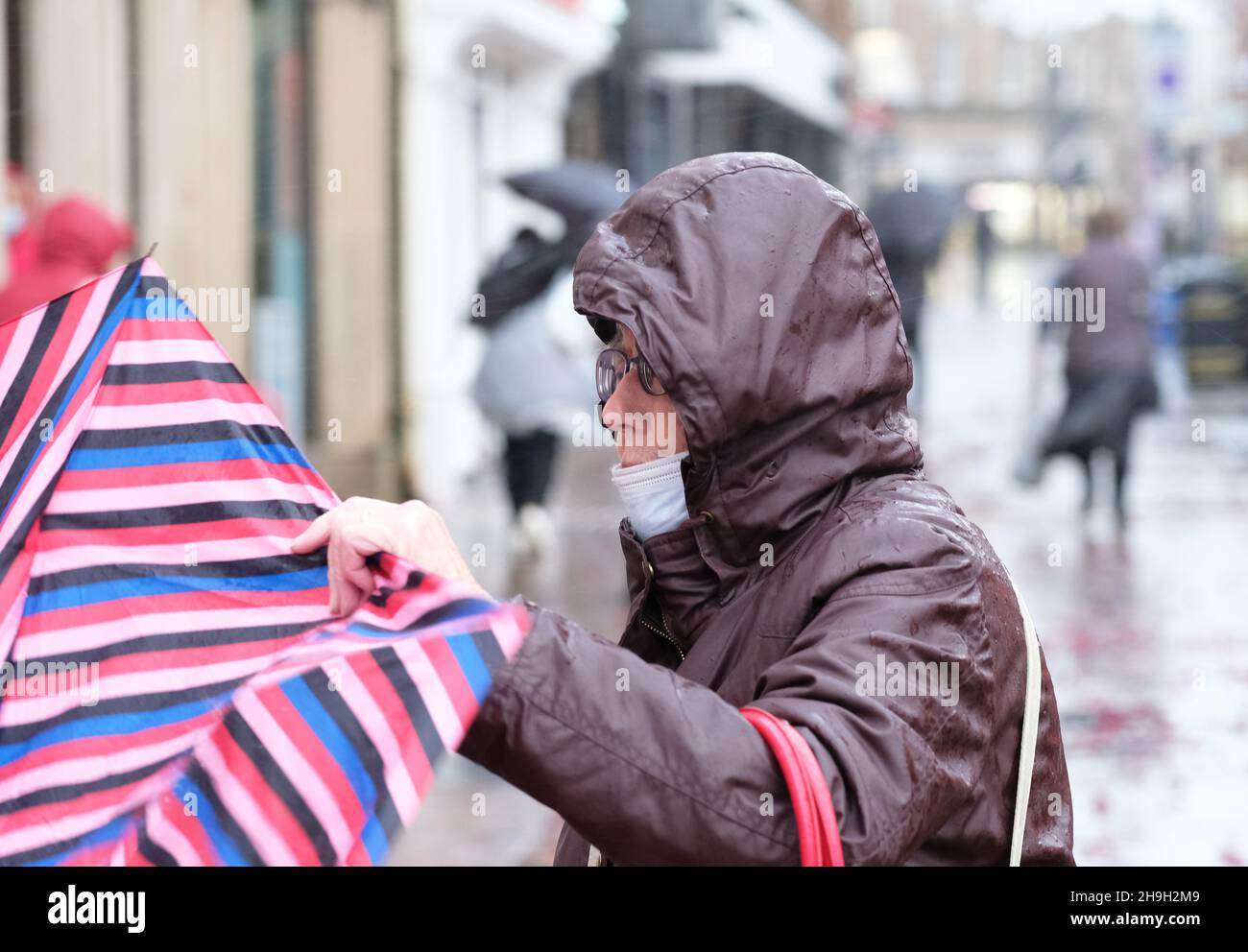 Hereford, Herefordshire, Royaume-Uni - Mardi 7 décembre 2021 - Royaume-Uni Météo - Un shopper lutte pour tenir sur son parapluie dans le centre-ville de Hereford lors de vents forts et de fortes pluies que Storm Barra aprroaches de l'Ouest - photo Steven May / Alamy Live News Banque D'Images