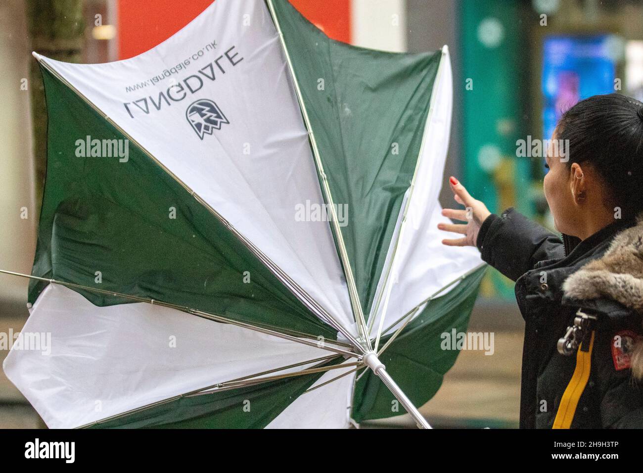 Parapluie brisé, inversé, endommagé et piquant lors d'un jour de pluie à Preston, dans le Lancashire.Météo Royaume-Uni.Décembre 2021.Vents forts et froids vers le nord pour les amateurs de shopping dans le centre-ville.Crédit; MediaWorldImages/AlamyLiveNews Banque D'Images