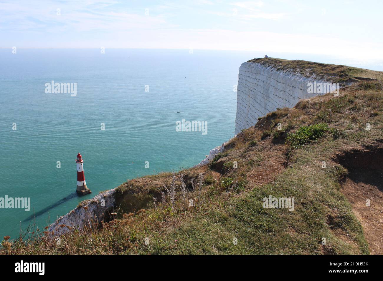 Falaises de Seven Sisters.Vue sur le phare de Beachy Head qui jette une ombre sous les falaises blanches, bleu clair de l'océan Atlantique et ciel d'été (Sussex) Banque D'Images