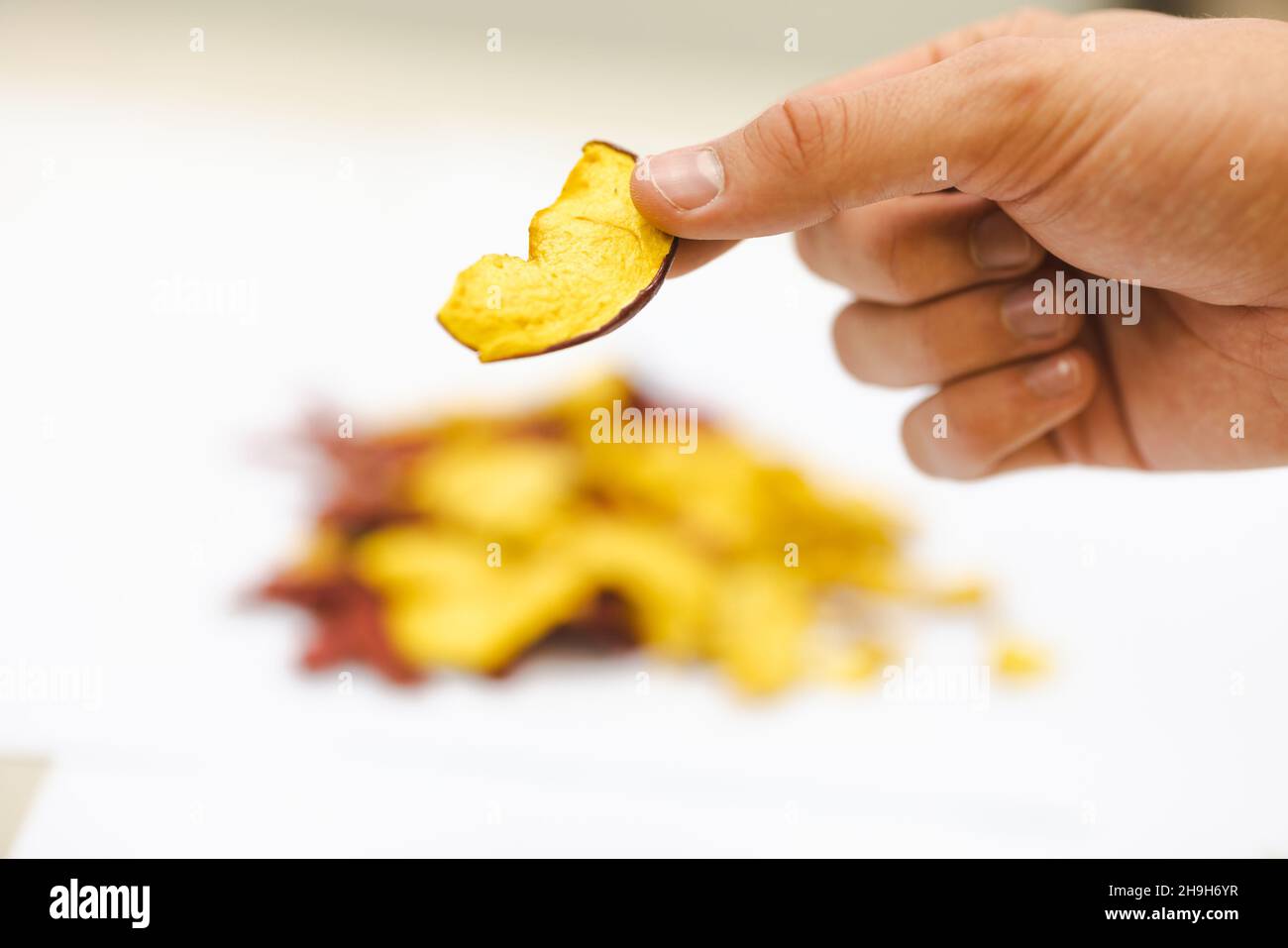 Des pommes tranchées et séchées sur un tapis roulant dans une usine de transformation des aliments.Fruits sains, production alimentaire et concept automatisé de l'industrie alimentaire. Banque D'Images