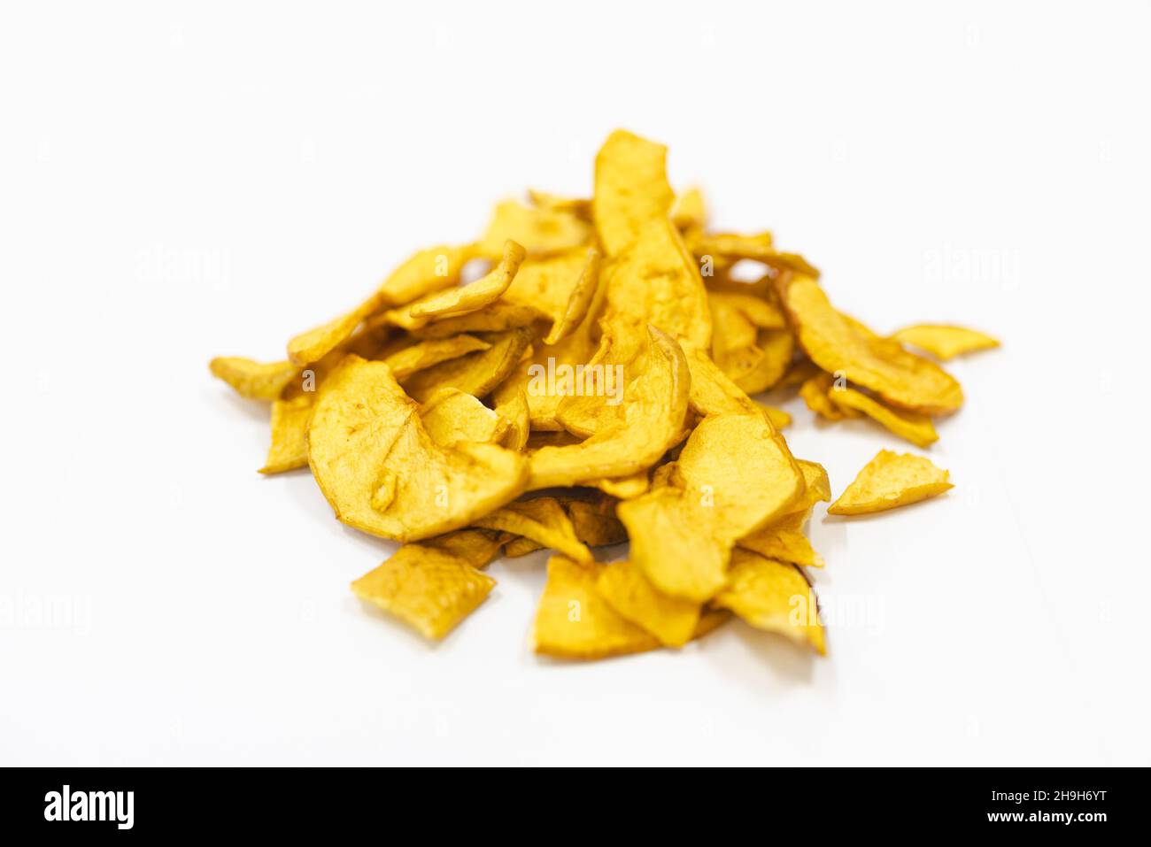 Des pommes tranchées et séchées sur un tapis roulant dans une usine de transformation des aliments.Fruits sains, production alimentaire et concept automatisé de l'industrie alimentaire. Banque D'Images