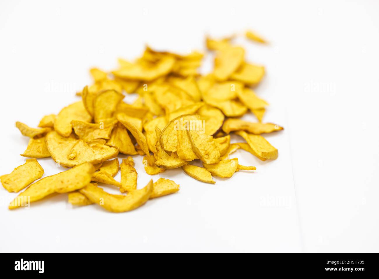 Des pommes tranchées et séchées sur un tapis roulant dans une usine de transformation des aliments.Fruits sains, production alimentaire et concept automatisé de l'industrie alimentaire. Banque D'Images