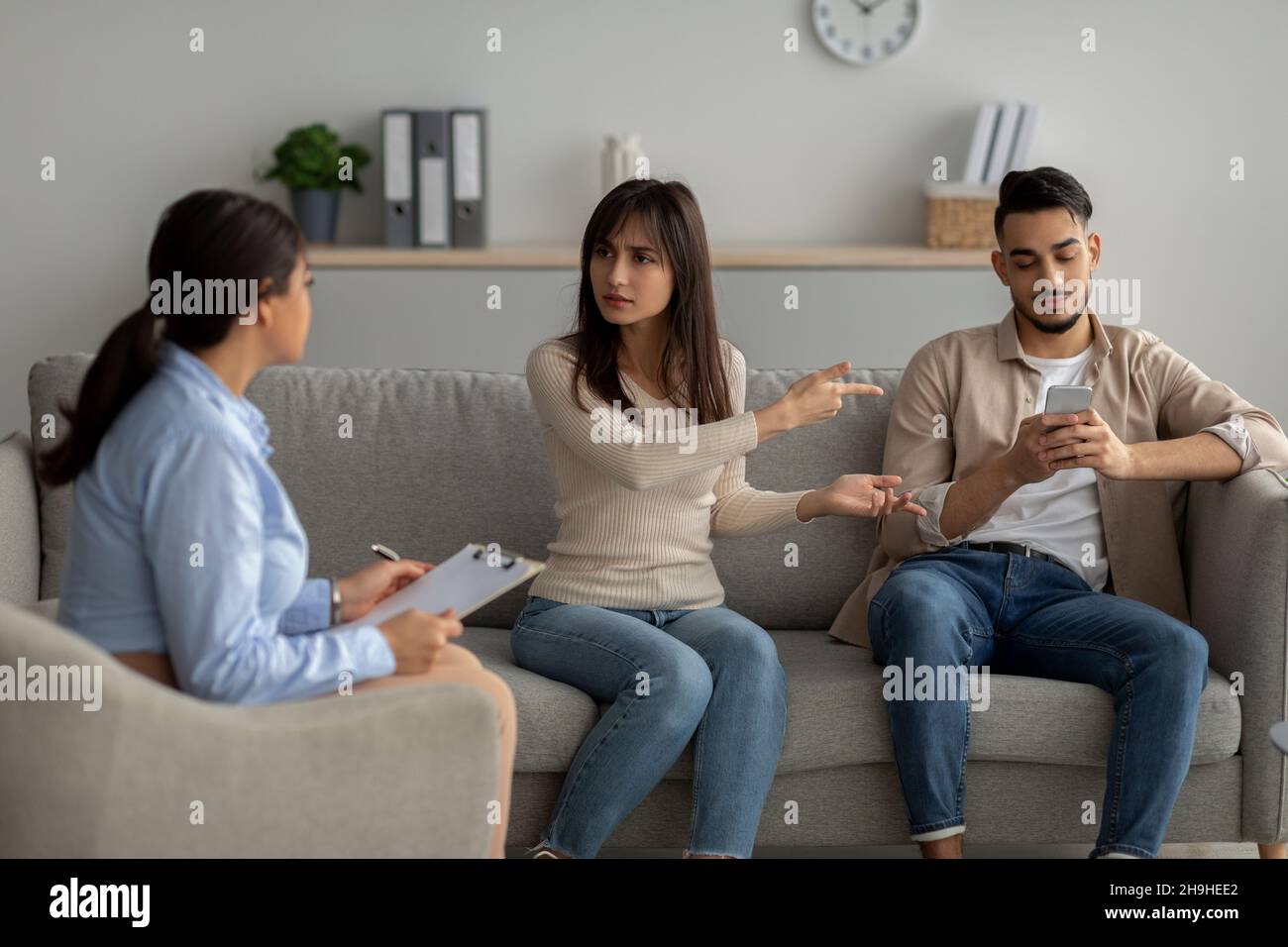 Une femme arabe irritée se plaignait de la dépendance de son mari au smartphone lors d'une consultation psychologique Banque D'Images