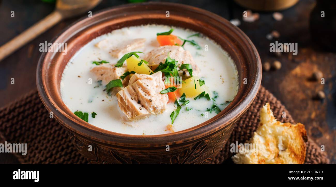 Soupe crémeuse finlandaise chaude avec saumon et légumes dans un ancien bol en céramique sur fond de bois ancien.Style rustique. Banque D'Images