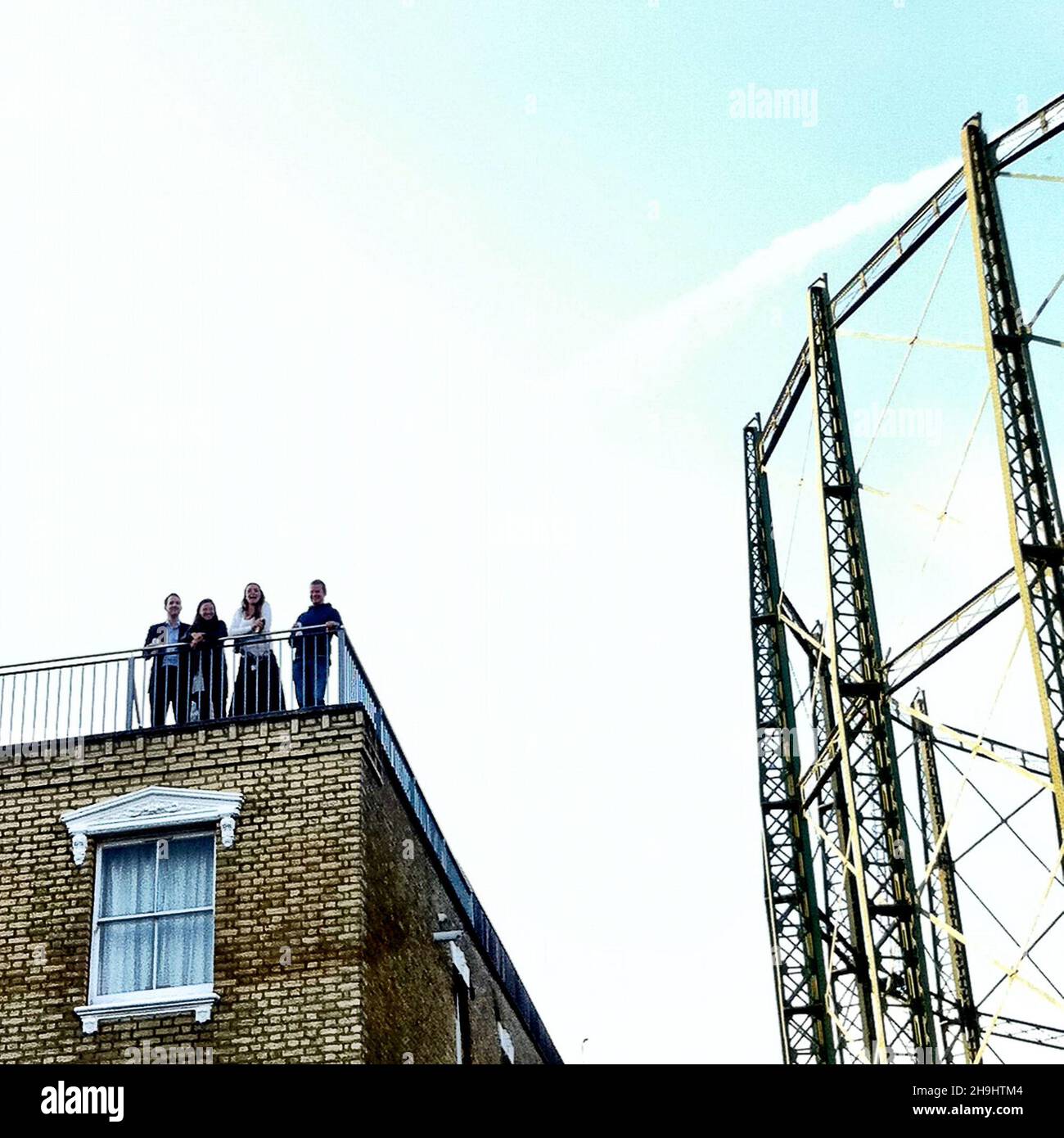 Spectateurs regardant le cricket à l'Oval de Londres depuis un toit voisin à côté des installations de gaz Banque D'Images