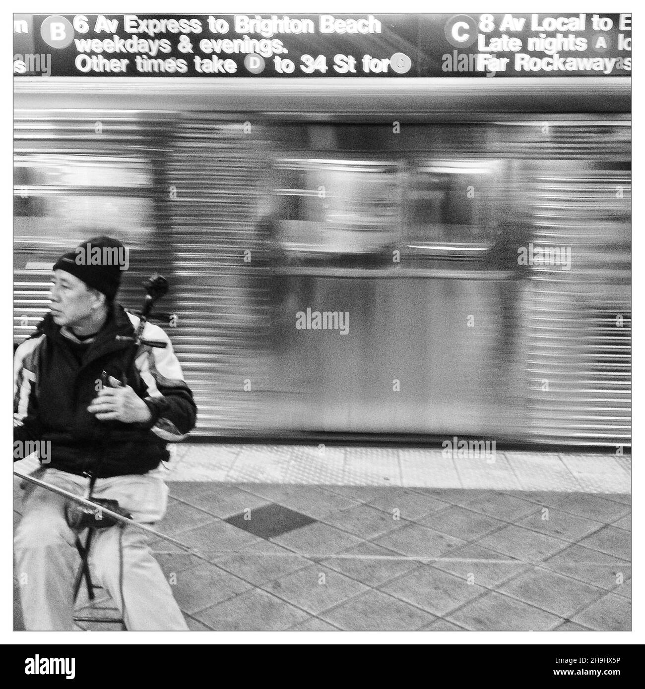 Un busseur chinois sur le métro de New York jouant de la musique (une image prise avec une application appelée Snapseed dans le cadre d'une série d'images expérimentales prises et traitées sur l'iPhone) Banque D'Images