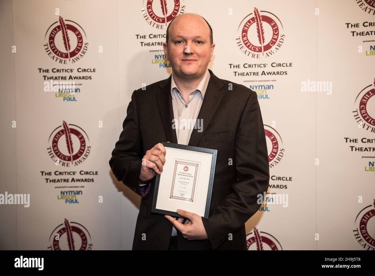 Mike Bartlett après avoir reçu son prix de meilleur nouveau jeu pour le roi Charles III lors des critiquess' Circle Theatre Awards 2014 au Prince of Wales Theatre, Londres Banque D'Images