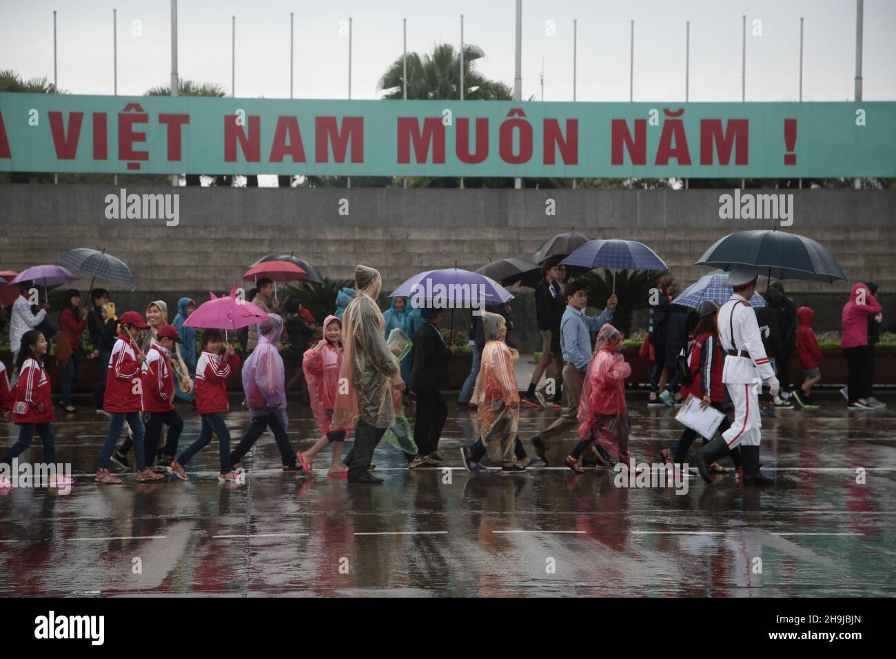 Touristes dans la pluie visitant le mausolée de Ho Chi min à Hanoi. D'une série de photos de voyage prises au Vietnam et au Cambodge. Banque D'Images