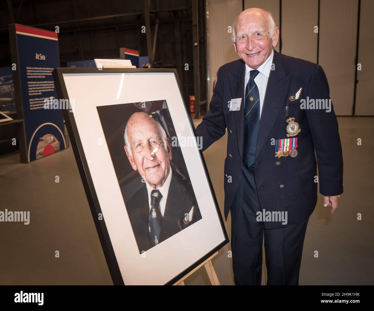 Bernard Carton (à droite) avec un portrait de lui-même par le photographe  Mike Stone à Hidden Heroes, un événement célébrant le rôle joué par des  bénévoles juifs dans la Royal Air Force