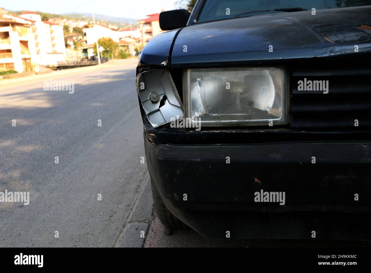 Une voiture noire avec le phare cassé Banque D'Images