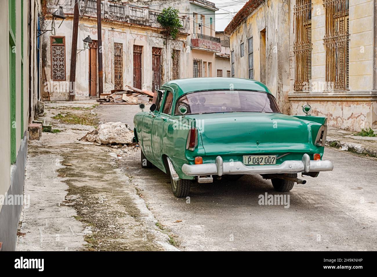 REGLA, CUBA - 22 DÉCEMBRE 2019 : un taxi vert d'époque est stationné dans une petite rue vide et déserte de la ville ou Regla près de la Havane à Cuba. Banque D'Images