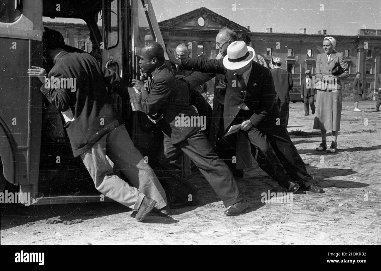 Varsovie, 1948-08-30.Œwiatowy Kongres Intelektualistów W Obronie Pokoju (25-28 VIII).Zwiedzanie stolicy.NZ. Uczestnicy Kongresu pchaj¹ zepsuty autobus.W tle ruiny Wojskowego Wiêzienia Œledczego. ka PAPVarsovie, le 30 août 1948.Congrès mondial des intellectuels pour la défense de la paix (25-28 août).Excursions autour de Varsovie.Photo : les participants au Congrès poussent un bus endommagé.Dans les ruines de fond de la prison militaire d'enquête. ka PAP Banque D'Images