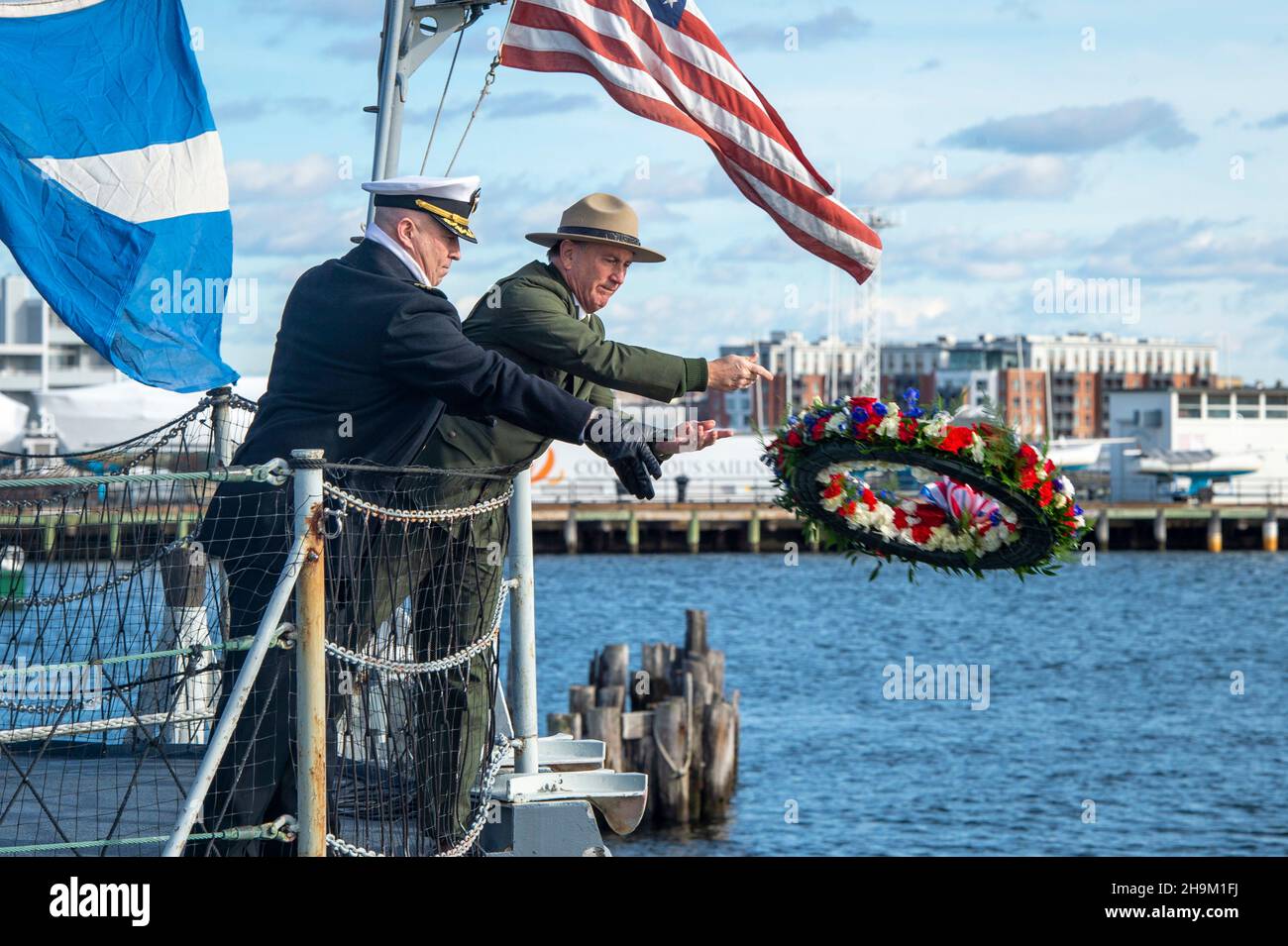 Boston, États-Unis.07ème décembre 2021.Cmdr. Marine américaineJohn Benda, commandant de l'USS Constitution, et Michael Creasey, directeur général du National Park Service Boston, lancent une couronne dans le port lors de la commémoration du 80e anniversaire de l'attaque de Pearl Harbor le 7 décembre 2021 à Boston, Massachusetts.Crédit : MC2 Skyler Okerman/US Navy/Alay Live News Banque D'Images