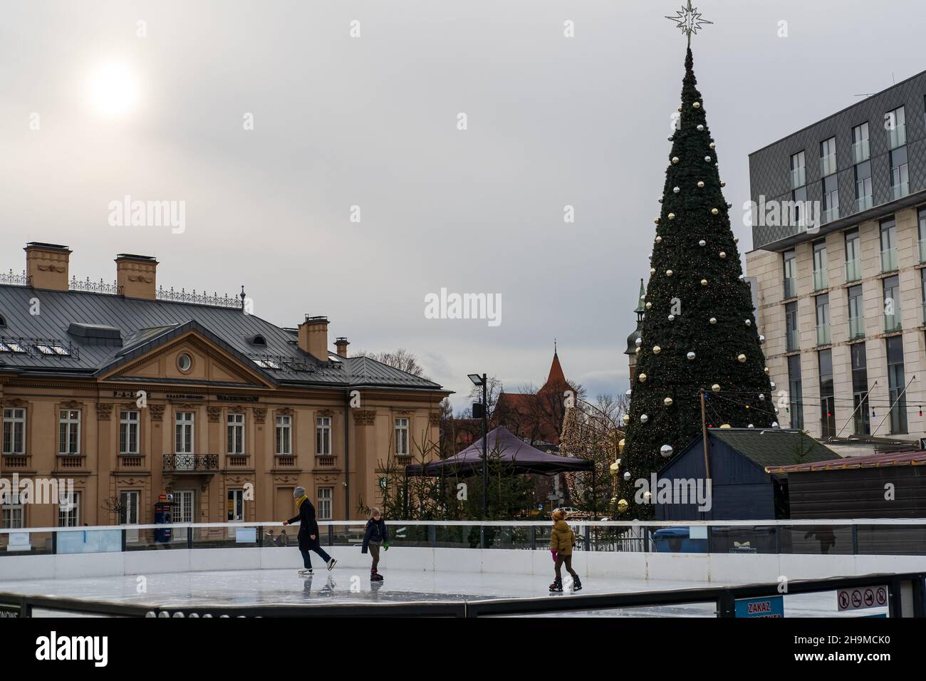 Les gens visitent le marché de Noël à Cracovie, le patinage sur glace familial, la mère avec des enfants, les vacances d'hiver à Cracovie, Pologne Banque D'Images