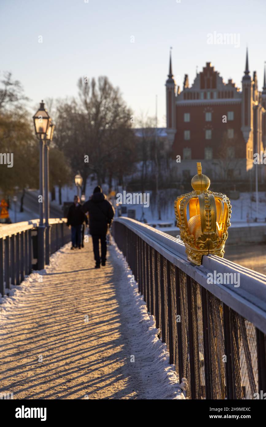 Stockholm en hiver.Les gens qui marchent sur le pont avec une couronne dorée sur Skeppsholmsbron avec Strandvagen en arrière-plan. Banque D'Images