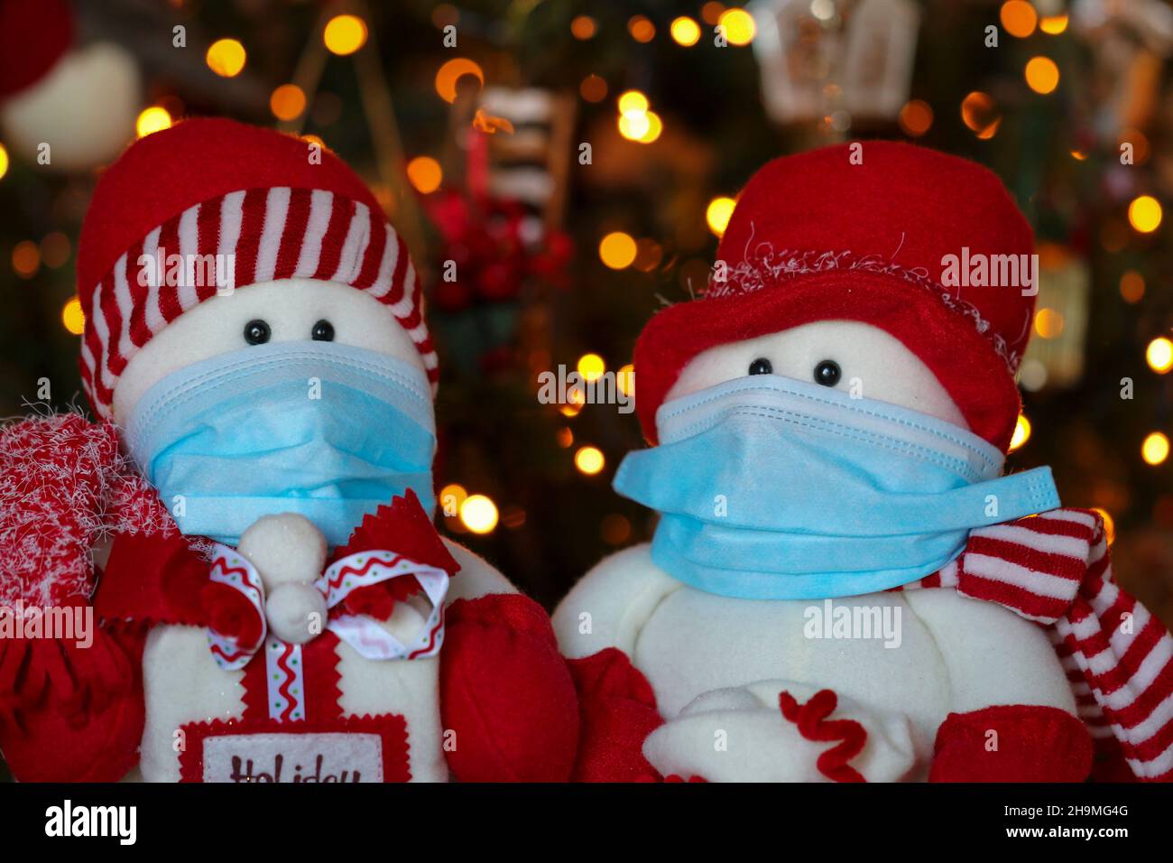 Jouets de Noël portant un masque ou un masque de protection.Don de concept, socialisation, visite, célébrations pendant la pandémie du coronavirus Covid-19 Banque D'Images