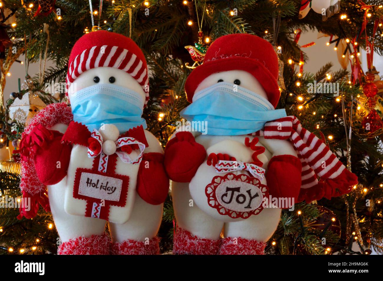 Jouets de Noël portant des masques de visage ou des revêtements de visage, visite avec des cadeaux.Thème socialisation, célébrations durant la pandémie du coronavirus Covid-19 Banque D'Images