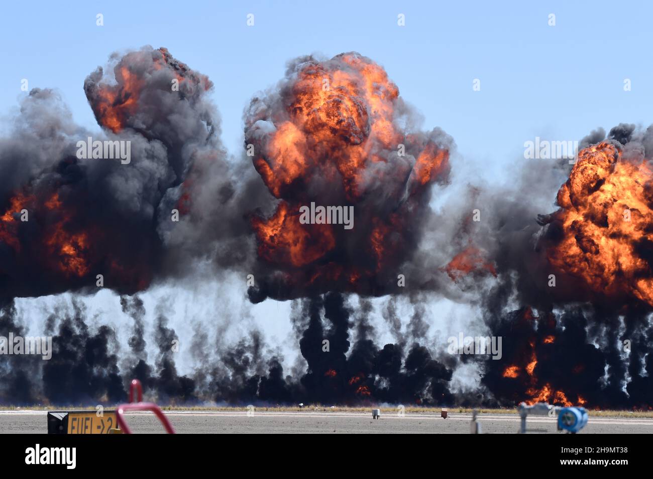 La fumée et la flamme provenant de l'ordnance simulée s'enflamme près de la piste lors de la démonstration MAGTF au MCAS Miramar Airshow Banque D'Images