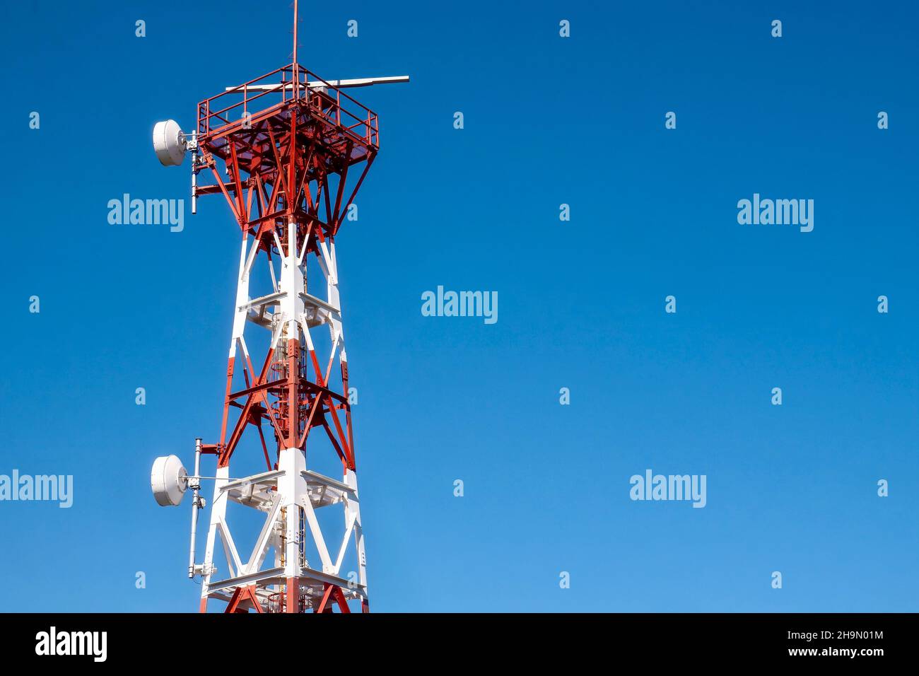 La partie supérieure d'une balise radar fixe à transpondeur, ou racon, utilisée comme aide à la navigation maritime pour marquer un danger de sécurité, avec un fond bleu ciel Banque D'Images
