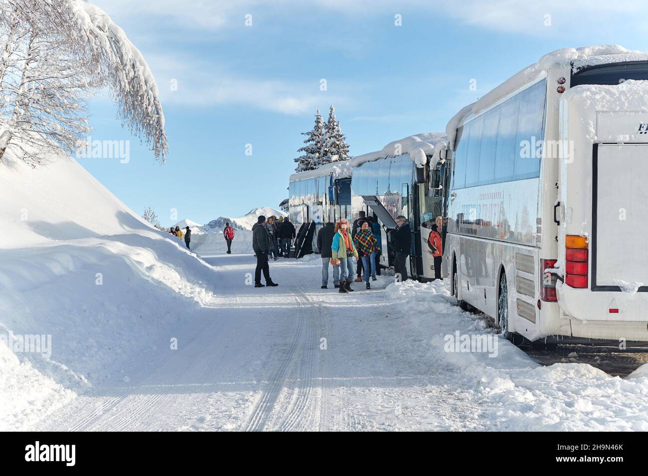 Groupe de ski avec bus dans les Alpes enneigées Banque D'Images