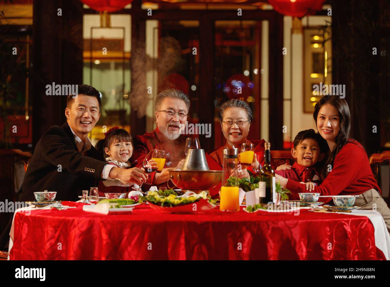 La famille orientale boit un toast pour célébrer le nouvel an dans le jardin chinois Banque D'Images