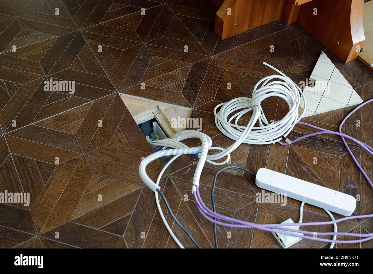 Fils électriques sur le sol.Câbles et blocs d'extension, rangement des appareils électriques. Banque D'Images