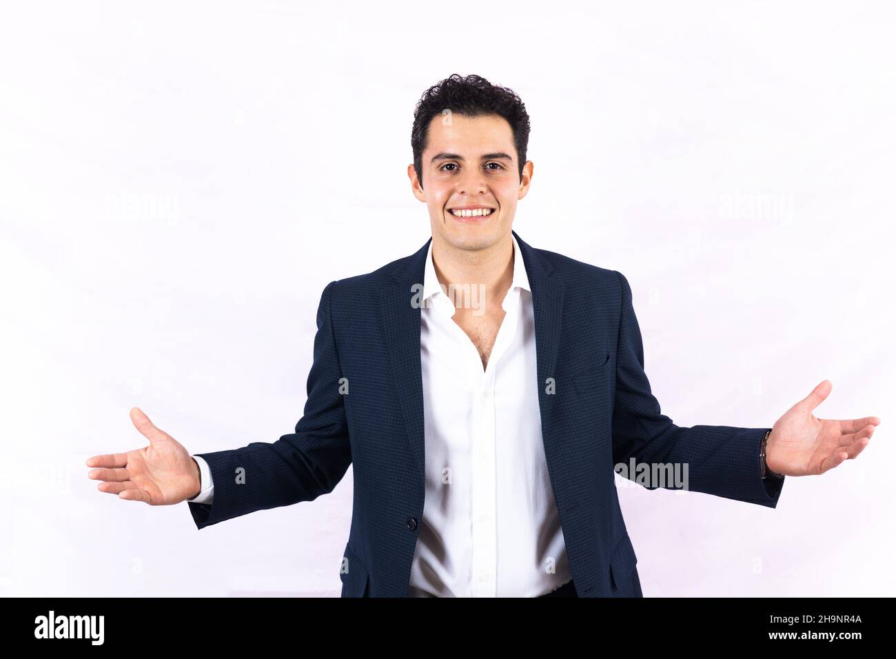Portrait d'un jeune homme d'affaires latin prospère aux bras ouverts sur fond blanc au Mexique en Amérique latine Banque D'Images