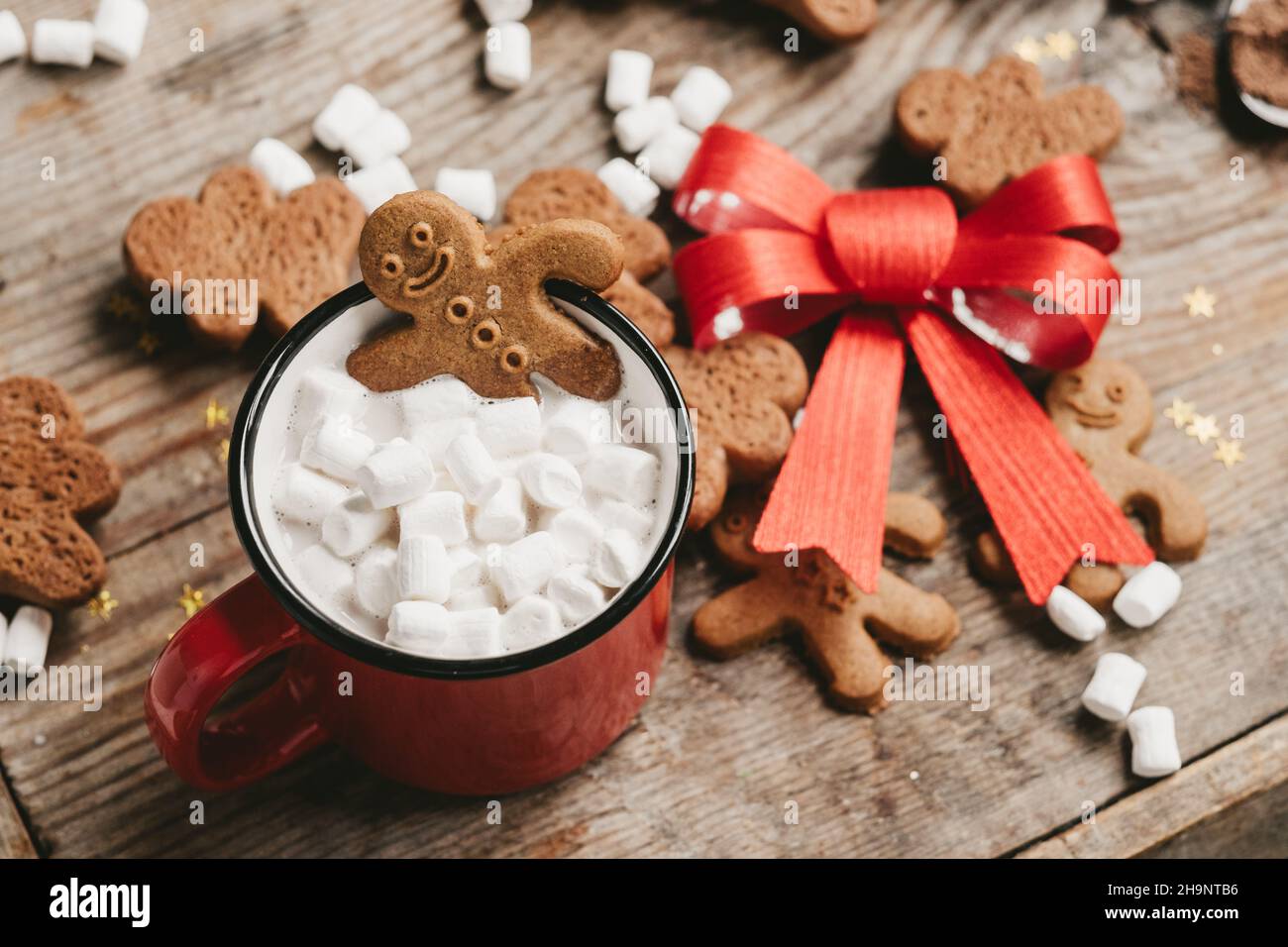 gingembre dans une tasse de cacao avec un gros noeud rouge sur un fond en bois, vue de dessus.Divers bonbons de Noël avec une tasse de cacao sur la table.Noël Banque D'Images