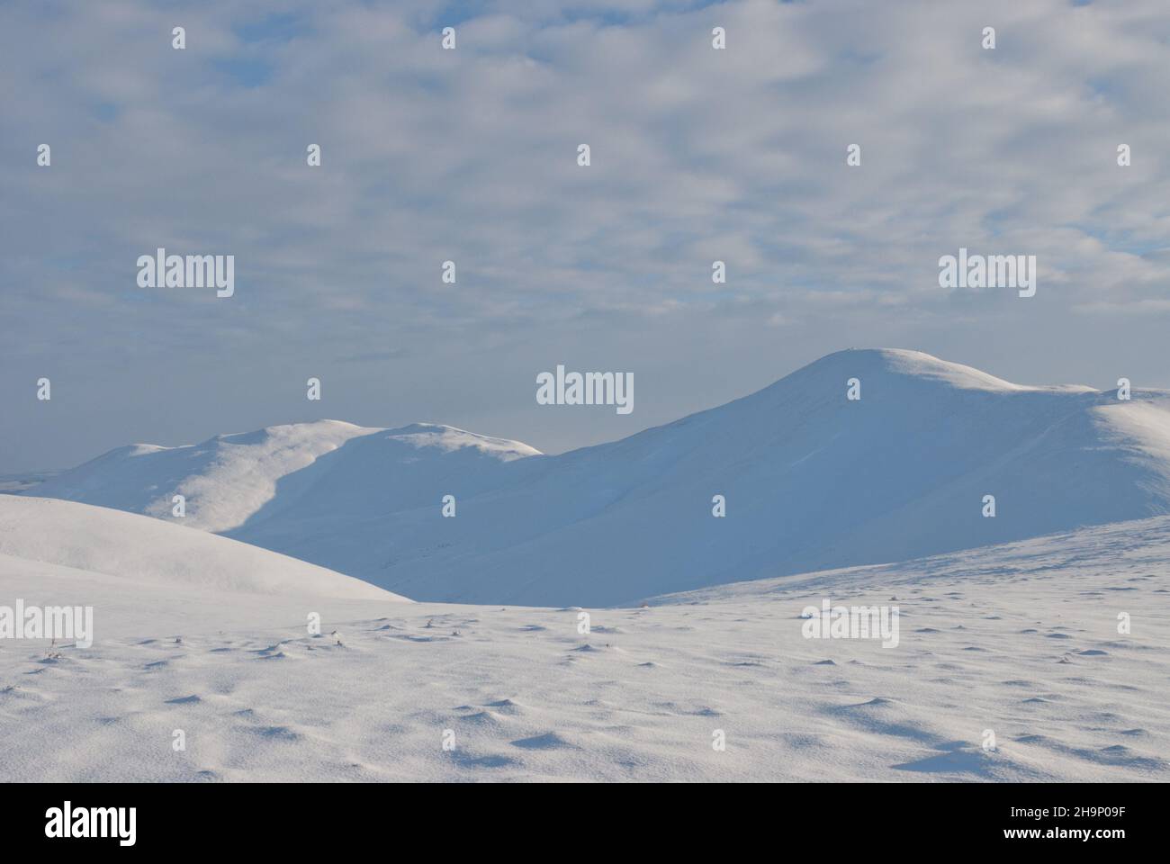 Scène hivernante des collines de Pentland pendant l'hiver enneigé du 2009/2010, montrant des marcheurs traversant une crête enneigée. Banque D'Images