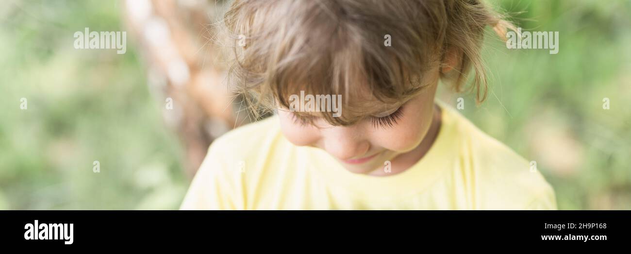 flou de mouvement photo défoqué de portrait sourire enfant ensoleillé candid caucasien garçon avec blond long ondulé ou cheveux bouclés et lumière du soleil sur le visage sur la nature pays Banque D'Images