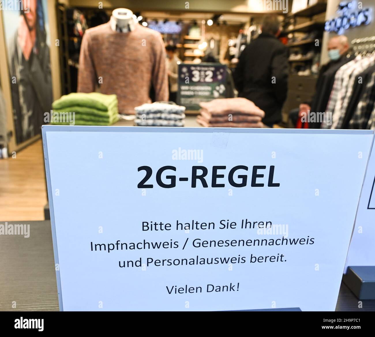 Mayence, Allemagne.07th décembre 2021.À l'entrée du magasin de mode Engbers dans le centre-ville de Mayence, il y a un panneau qui lit '2G règle.Veuillez avoir votre preuve de vaccination/génétique et votre pièce d'identité à portée de main.Merci ! ».La ville de Mayence a modifié son ordonnance Corona.Selon cela, les personnes ayant un bracelet de 2G du marché de Noël peuvent également faire du shopping dans les magasins de Mayence.(À dpa : « les achats de Noël avec preuve de vaccination font moins souvent des caisses enregistreuses ») Credit: Arne Dedert/dpa/Alamy Live News Banque D'Images