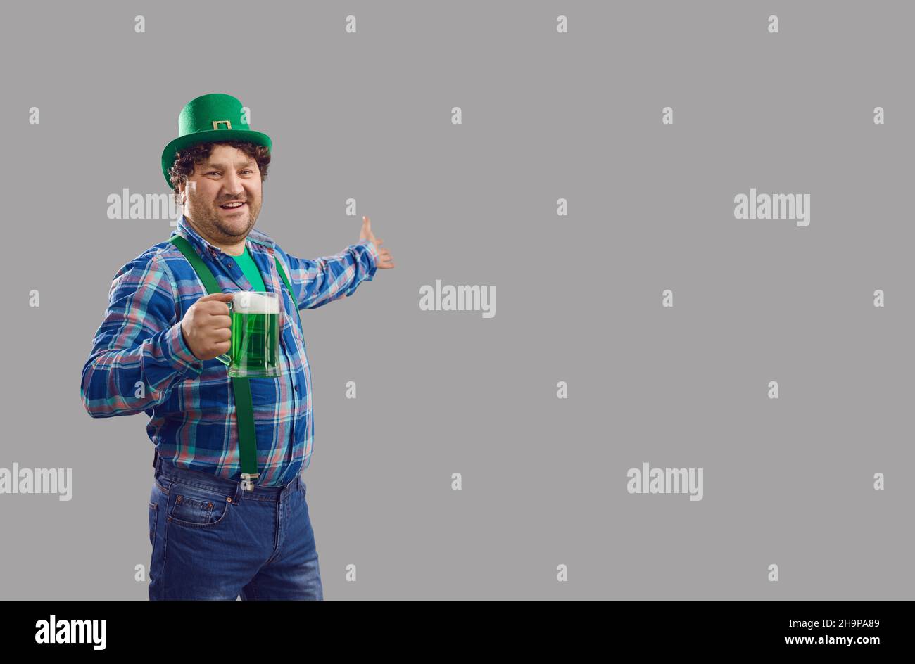 Homme en chapeau de leprechaun avec bière accueillant se joindre à la fête de la saint Patrick Banque D'Images