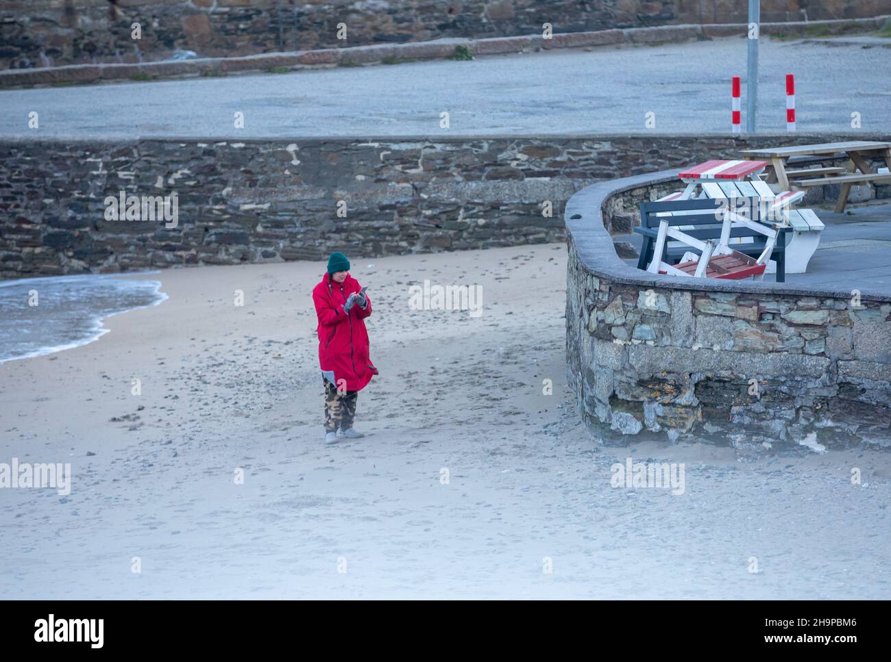 Portreath,Cornwall,8th décembre 2021,Une dame regardant son téléphone après avoir pris une photo des grandes vagues et des mers orageux à Portreath,Cornwall, Storm Barra continue au Royaume-Uni.La température était de 7C, mais avec des vents forts et un facteur de refroidissement du vent, elle a donné l'impression de 3C.La prévision sera des vents de rafales pour aujourd'hui jusqu'à ce soir le long de la côte cornish.Credit: Keith Larby/Alay Live News Banque D'Images