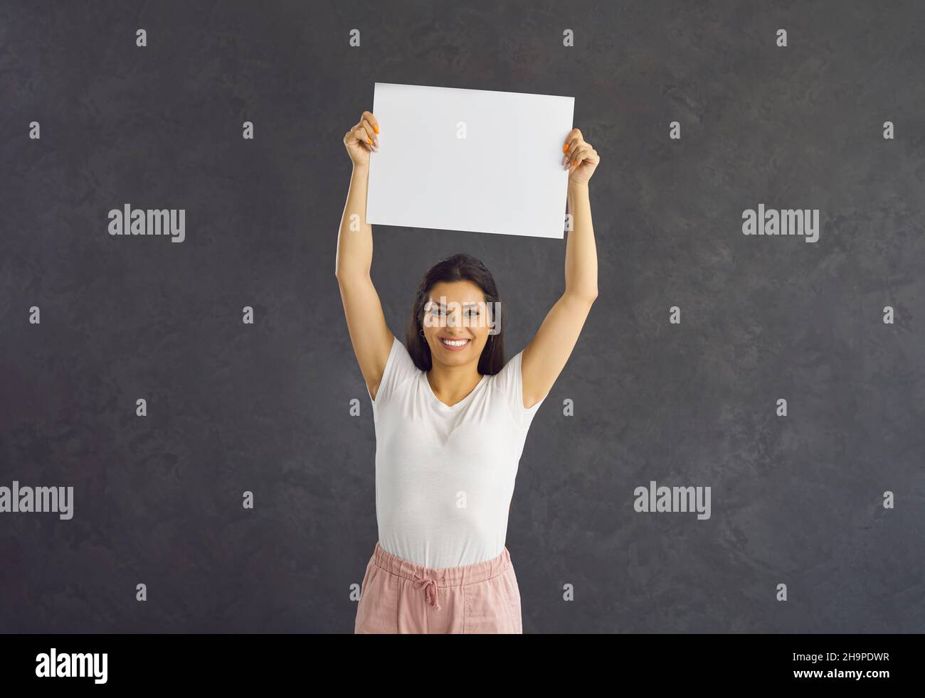 Portrait de femme souriante montre blanc maquette de feuille affaire Banque D'Images