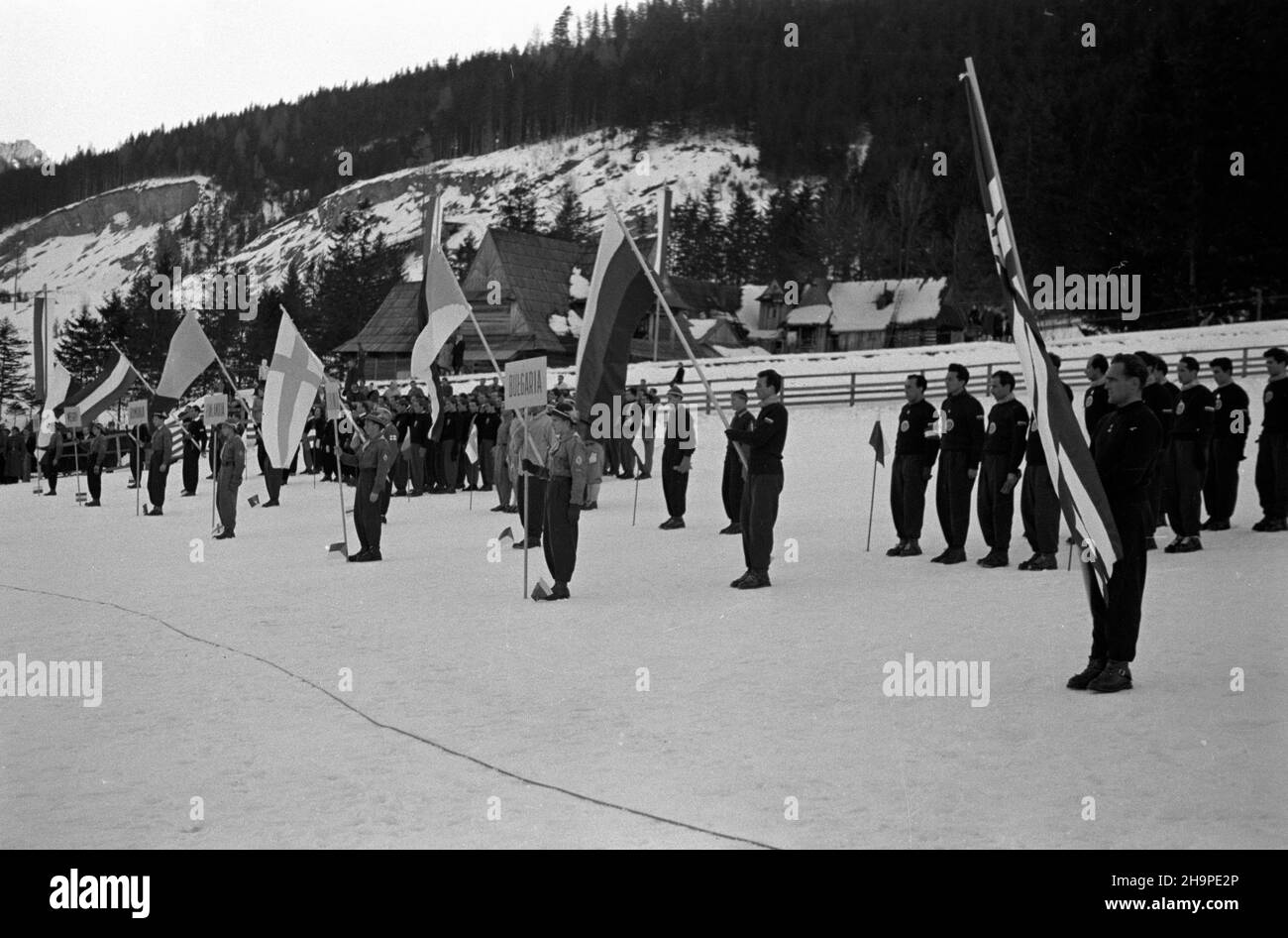 Zakopane, 1949-02-23.OD 23 lutego do 3 marca odbywa³y siê Miêdzynarodowe Zawody Narciarskie o Puchar Tatr.Zgromadzi³y un kilkudziesiêciu sportowców z Polski, Bu³garii, Czechos³owacji, Finlandii, Rumunii i i Wêgier.Pierwszego dnia, na stadionie Pod Krokwi¹, odby³o siê uroczyste otwarcie zawodów.Z prawej, z flagê Daniel Krzeptowski, chor¹¿y Polskiego Zwi¹zku Narciarskiego.OD lewej, ekipy sportowców z Polski, Wêgier, Rumunii, Finlandii, Czechos³owacji i Bu³garii. pw PAPZakopane, 23 février 1949.La compétition internationale de ski pour la coupe des montagnes Tatra a eu lieu le 23 février t Banque D'Images