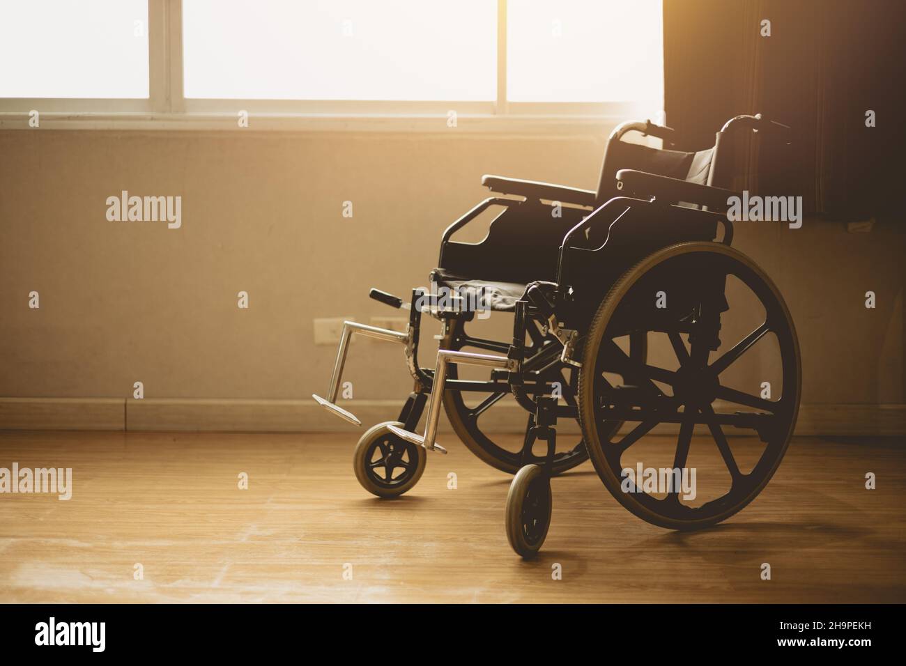 fauteuil roulant dans la chambre de l'hôpital aux fenêtres, lumière du soleil le matin Banque D'Images