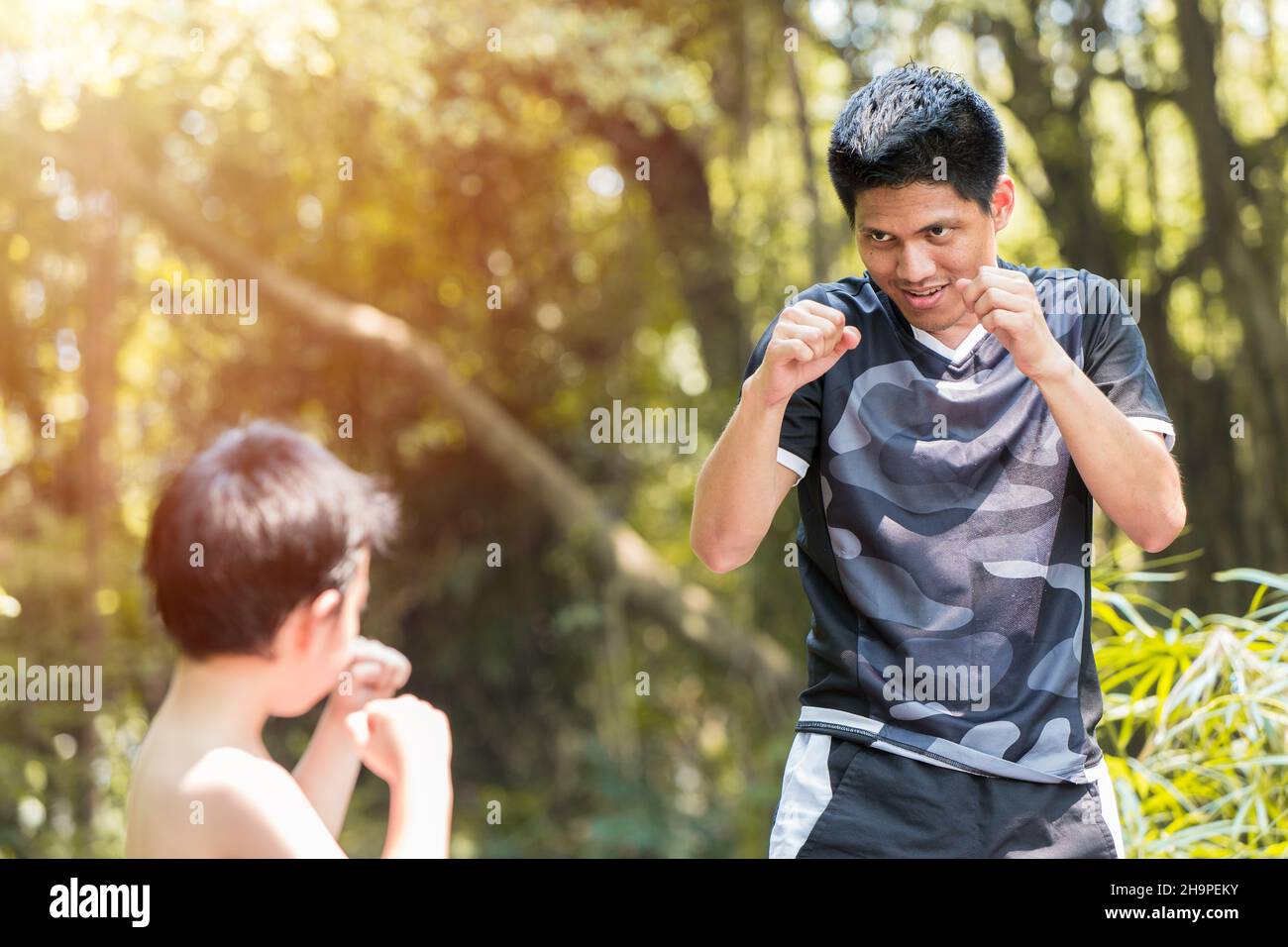 Boxe pour enfants. Boxeur pour jeunes garçons pratique les coups muay Thai avec entraîneur de père. Banque D'Images