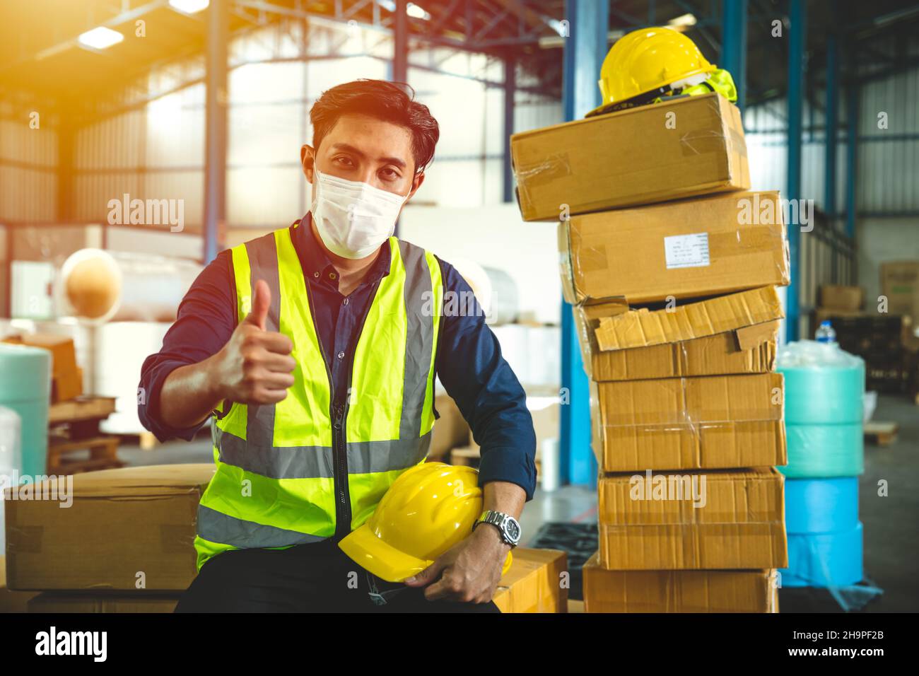 Un travailleur de l'ingénieur porte un écran facial ou un masque facial jetable. Service en usine pour prévenir la pollution par le coronavirus (Covid-19) ou la poussière de l'air en usine Banque D'Images