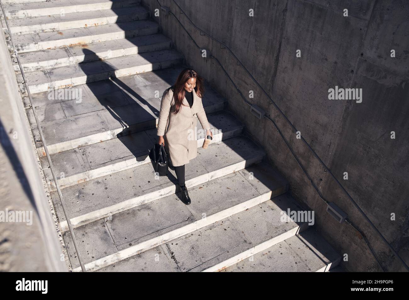 Vue de dessus de la jeune femme d'affaires afro-américaine qui descend les escaliers Banque D'Images