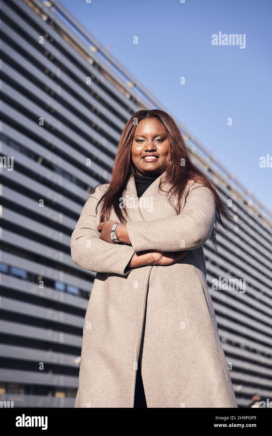 Bonne femme afro-américaine chef d'entreprise PDG debout devant le bâtiment de l'entreprise. Banque D'Images