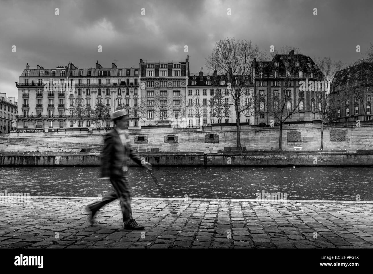Paris, France - 28 novembre 2021 : un homme au chapeau, habillé au début du siècle, marche dans les rues de Paris Banque D'Images