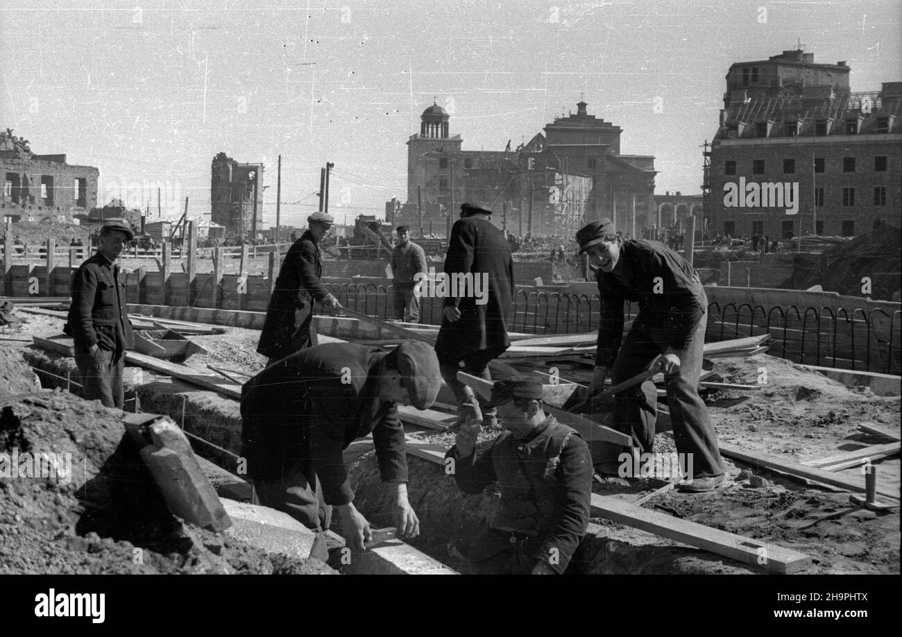 Varsovie, 1949-03.Budowa Trasy W-Z - ci¹gu komunikacyjnego Wschód-Zachód.NZ. Budowa jezdni ulicy Kapucyñskiej - uk³adanie krawê¿ników; W g³êbi gmach odbudowywanego Pa³acu Biskupów Krakowskich (P), koœció³ pw.œw.Anny wraz z dzwonnic¹ (C) oraz ruiny kamienicy przy ulicy Senatorskiej 3 i pa³acu przy ulicy Miodowej (L). mta PAP/Jerzy Baranowski Dok³adny dzieñ wydarzenia nieustalony.Varsovie, mars 1949.La construction de la route W-Z (ligne de communication est-ouest).Photo : la construction de la route de la rue Kapucynska; en arrière-plan, la construction du Palais épiscopal de Cracovie Banque D'Images