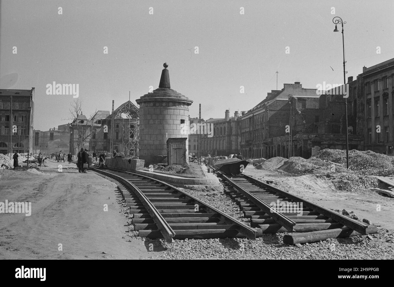 Varsovie, 1949-03.Budowa Trasy W-Z - ci¹gu komunikacyjnego Wschód-Zachód.NZ. Budowa jezdni i torowiska tramwajowego na T³omackiem (róg ulicy Bielañskiej i T³omackiej).W g³êbi: XVIII-wieczny pa³ac Przebdoydowskich (Radziwi³³ów) przy ulicy Bielañskiej 14, odbudowywany po zniszczeniach wojennych wed³ug projektu Bruna Zborowskiego; ruiny Banku Polskiego (P); na pierwszczenia planzoszoszosznaja Dok³adny rówomy 1786 darzyrówomy Kaœka.Varsovie, mars 1949.La construction de la route W-Z (ligne de communication est-ouest).Photo: La construction d'une chaussée et Banque D'Images