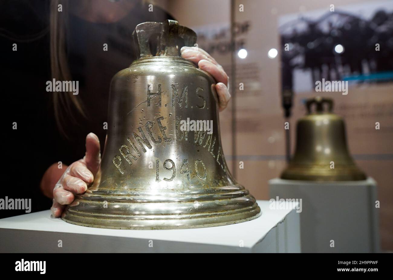 Victoria Ingles, conservateur principal au Musée national de la Marine royale, ajuste la cloche du navire du HMS Prince de Galles qui a été coulé avec le HMS Repulse après une attaque aérienne japonaise le 10 1941 décembre.842 hommes ont perdu la vie dans ce qui est l'une des pires catastrophes de l'histoire navale britannique.Date de la photo: Mercredi 8 décembre 2021. Banque D'Images