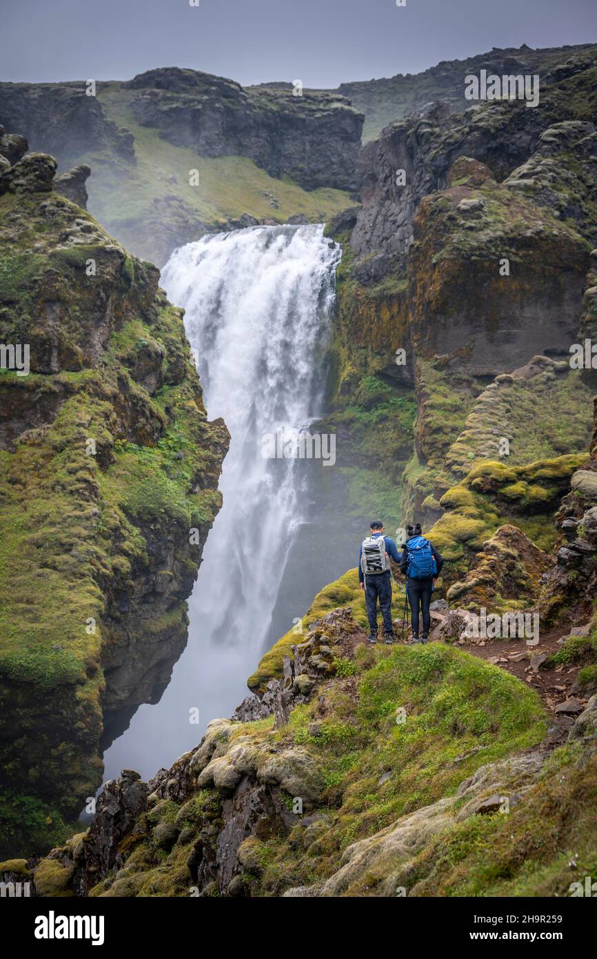 Randonneurs à une cascade, paysage au sentier de randonnée de Fimmvoerouhal, Islande du Sud Banque D'Images