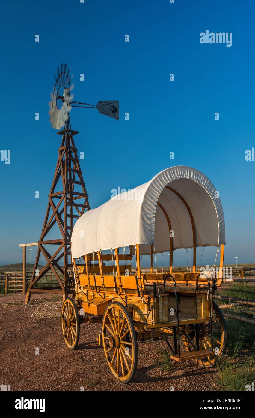 Wagon couvert, pompe à vent à l'entrée de Brush Creek Ranch, près de Tenmile, Wyoming, États-Unis Banque D'Images