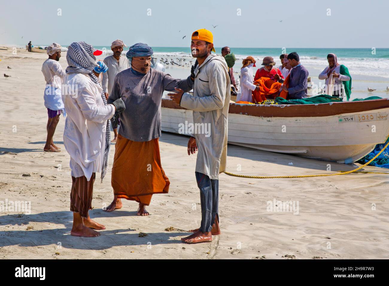 Pêcheurs transportant des filets sur la plage, Salalah, Salalah, Dhofar, Oman Banque D'Images