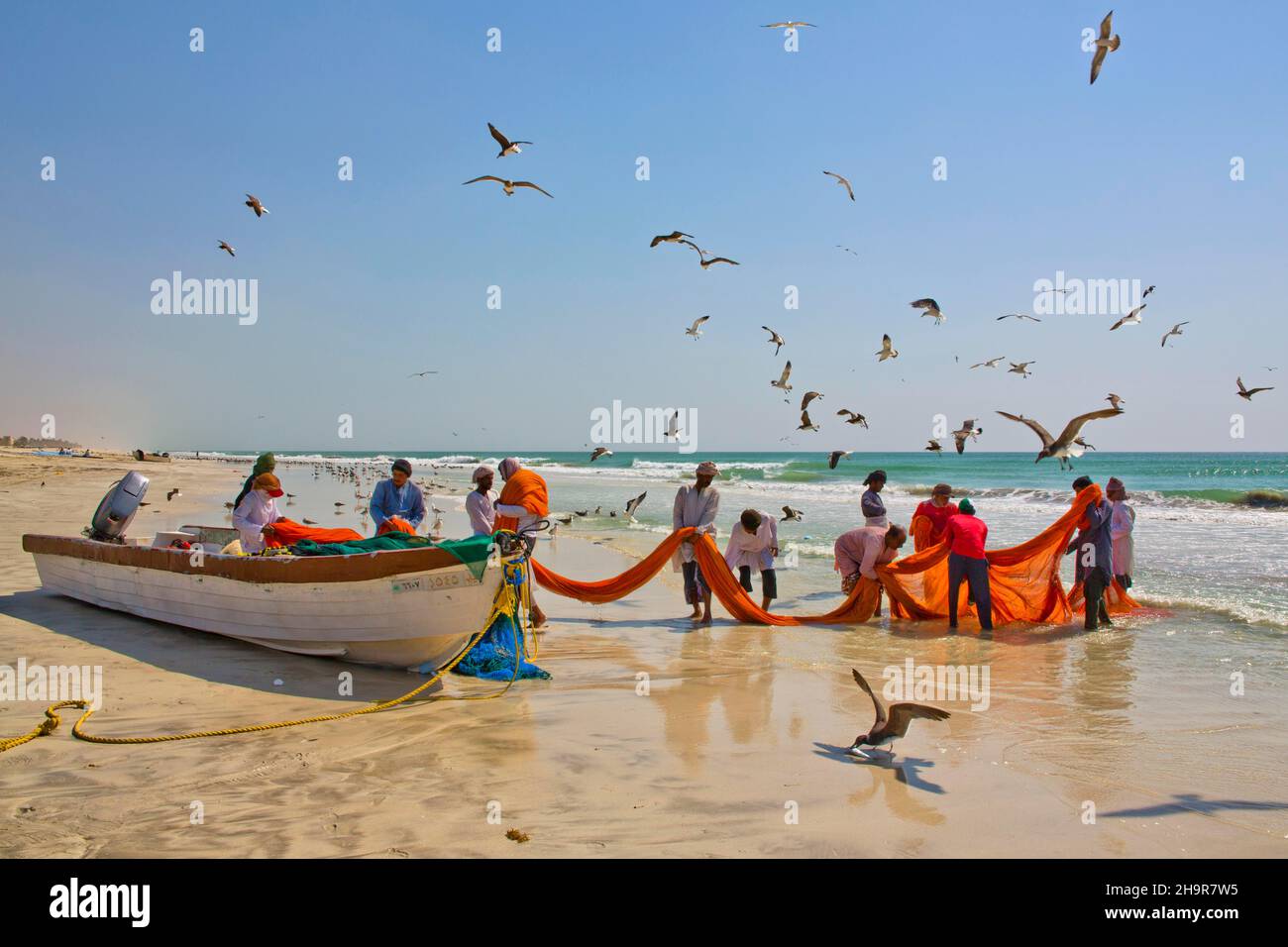 Pêcheurs transportant des filets sur la plage, Salalah, Salalah, Dhofar, Oman Banque D'Images